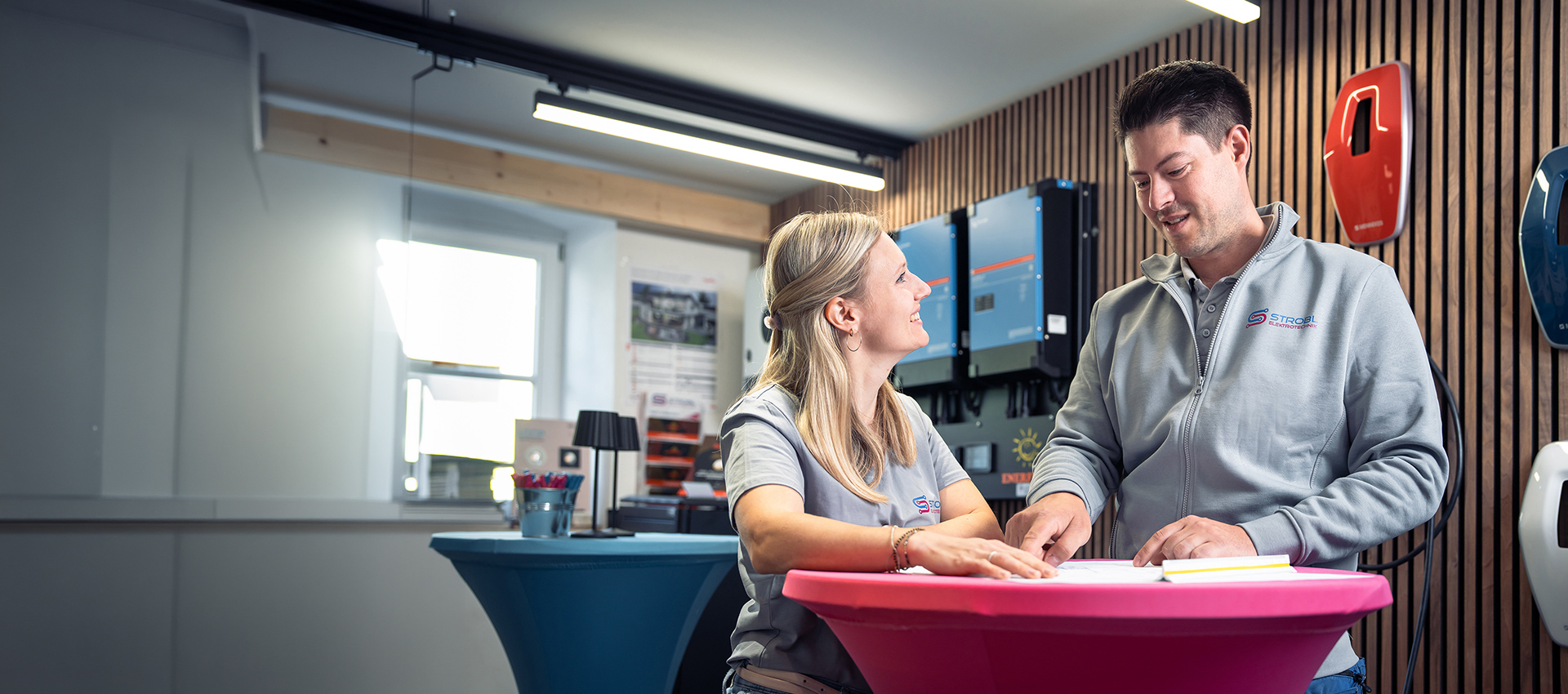 Beratungsgespräch im Showroom vor Wallbox und Wechselrichtern