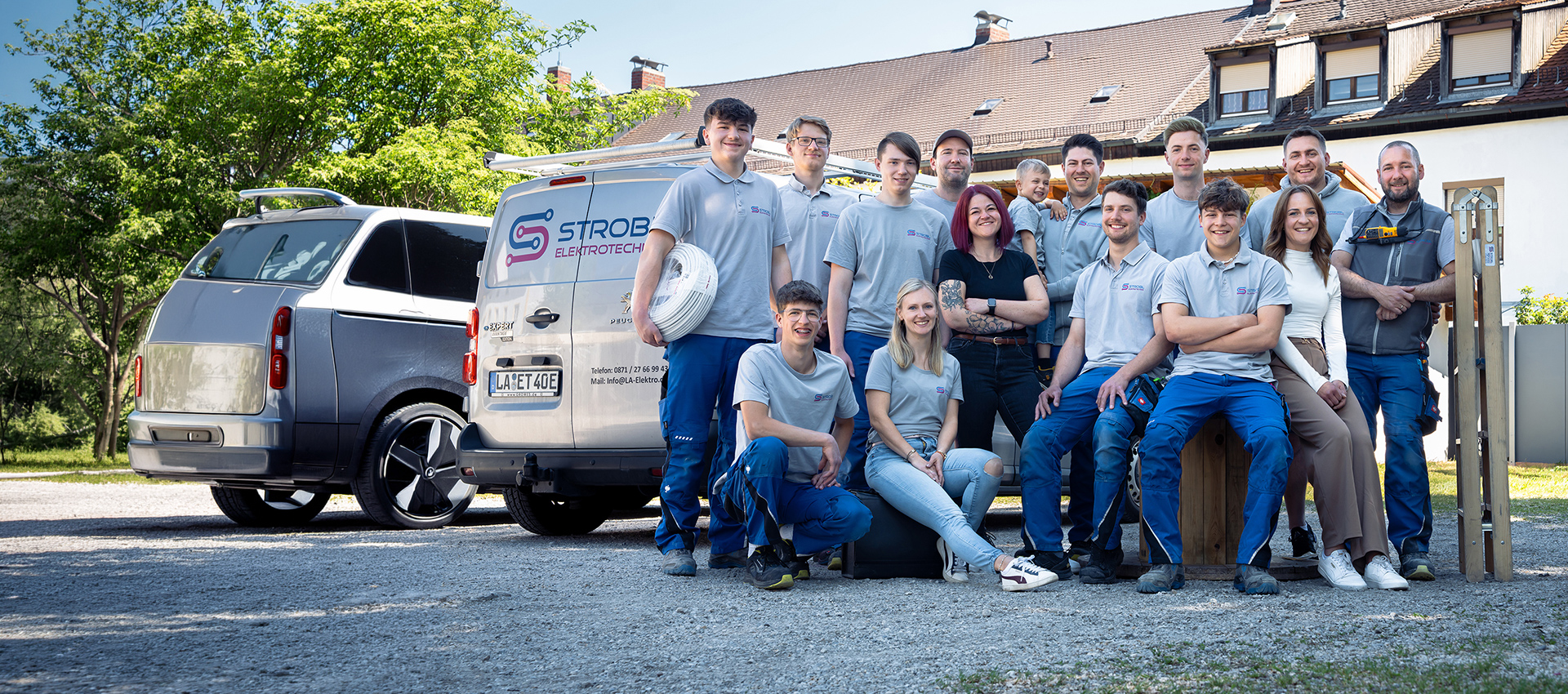 Gesamtes Strobl-Team vor Firmengebäude und Firmenfahrzeug